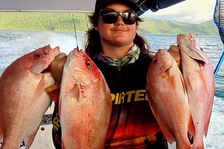 a man holding a fish in the water