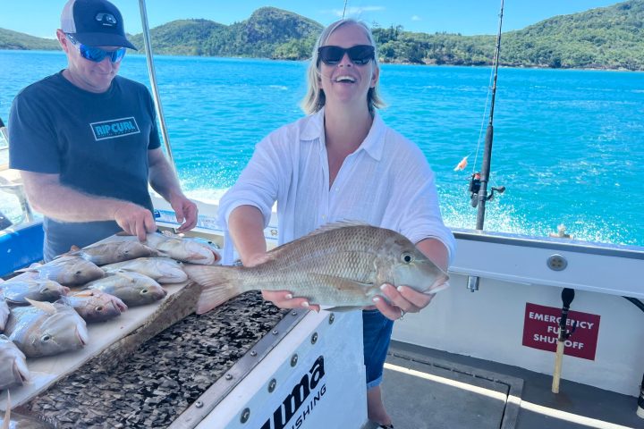 a person holding a fish on a boat in the water